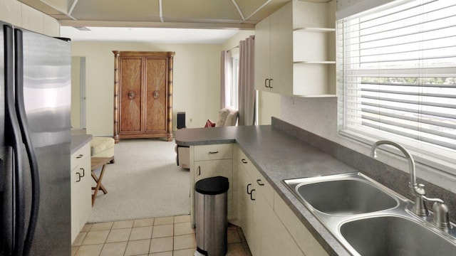 6035 19th St NE, Saint Petersburg, FL 33703 - kitchen with stainless steel fridge, a sink, a peninsula, open shelves, and light tile patterned floors