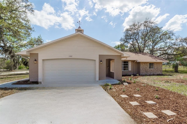 ranch-style house featuring brick siding, driveway, and an attached garage