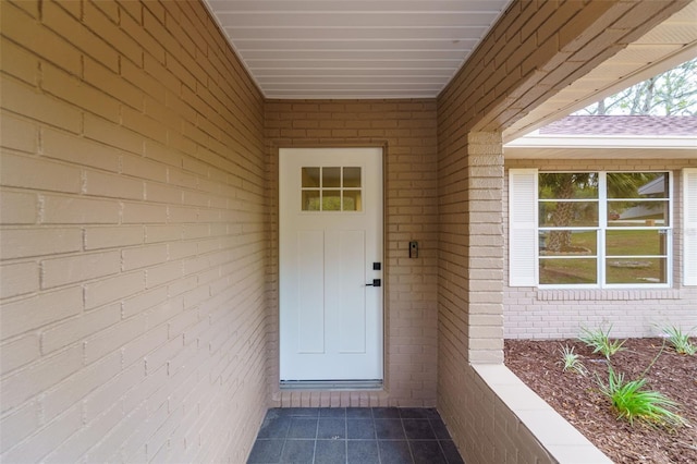 view of exterior entry featuring brick siding