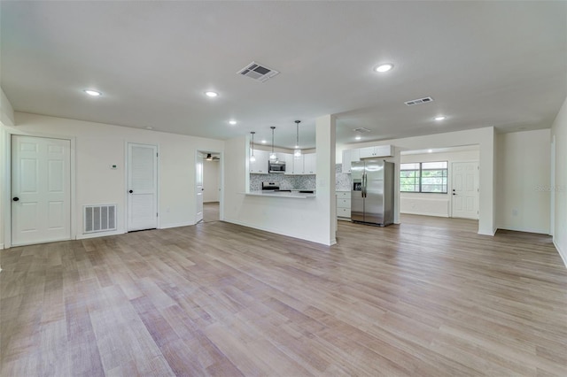 unfurnished living room with visible vents, light wood-style floors, and recessed lighting