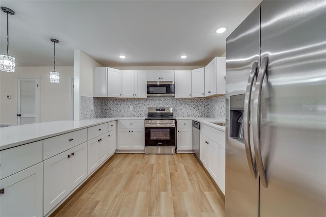 kitchen with light countertops, light wood-style flooring, white cabinets, and stainless steel appliances