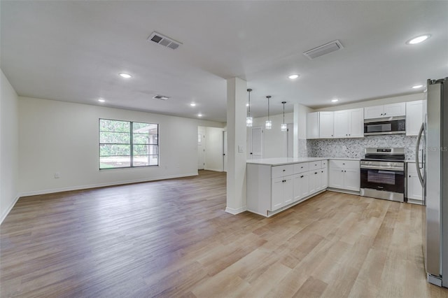 kitchen featuring backsplash, light wood-style flooring, stainless steel appliances, and visible vents