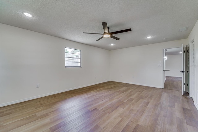 empty room with light wood-style flooring, a textured ceiling, baseboards, and ceiling fan