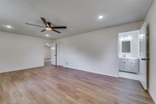 unfurnished room featuring baseboards, visible vents, light wood-style flooring, and ceiling fan