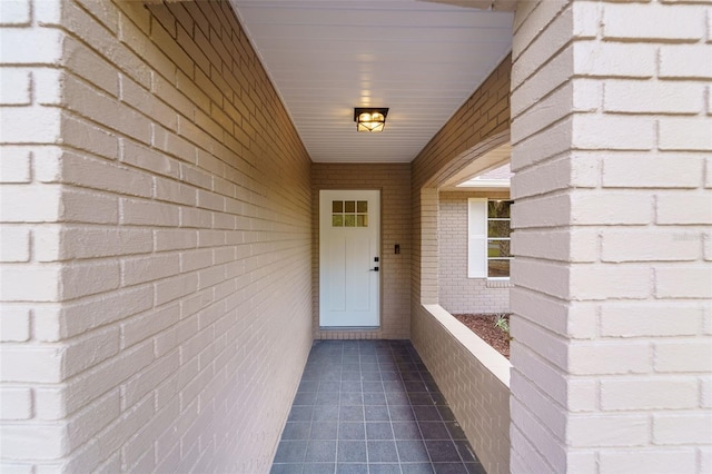 entrance to property featuring brick siding