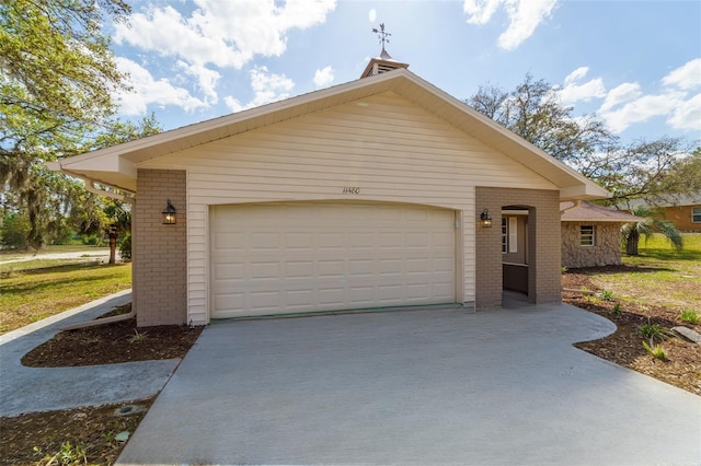 view of front of home featuring brick siding, a garage, and concrete driveway