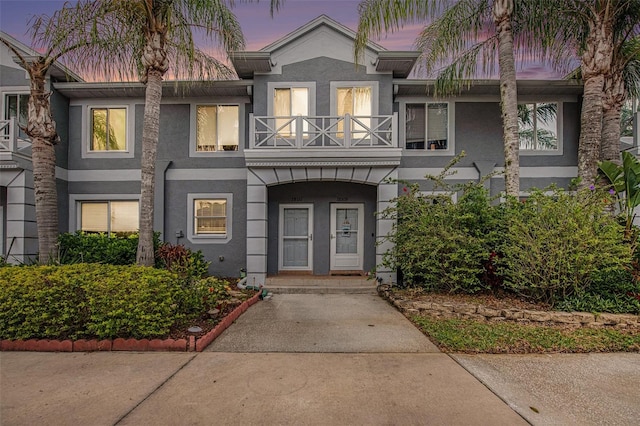 multi unit property featuring a balcony and stucco siding