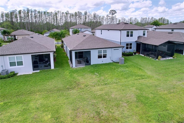 20983 Monza Loop, Land O Lakes, FL 34638 - back of house with a sunroom, a residential view, a yard, and roof with shingles