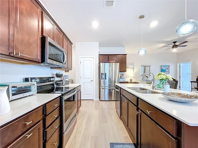 20983 Monza Loop, Land O Lakes, FL 34638 - kitchen with stainless steel appliances, a sink, decorative light fixtures, light wood-style floors, and ceiling fan