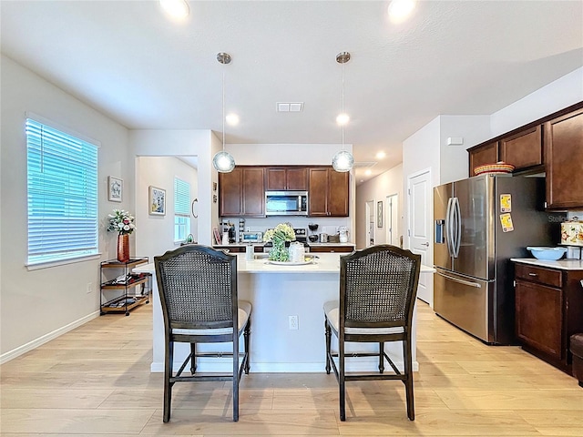 20983 Monza Loop, Land O Lakes, FL 34638 - kitchen with stainless steel appliances, dark brown cabinets, light countertops, a kitchen breakfast bar, and recessed lighting