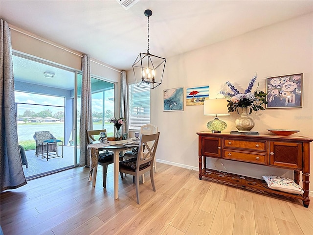 20983 Monza Loop, Land O Lakes, FL 34638 - dining space featuring light wood-style flooring, a chandelier, and baseboards