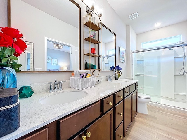20983 Monza Loop, Land O Lakes, FL 34638 - full bath with toilet, double vanity, a shower stall, and wood finished floors