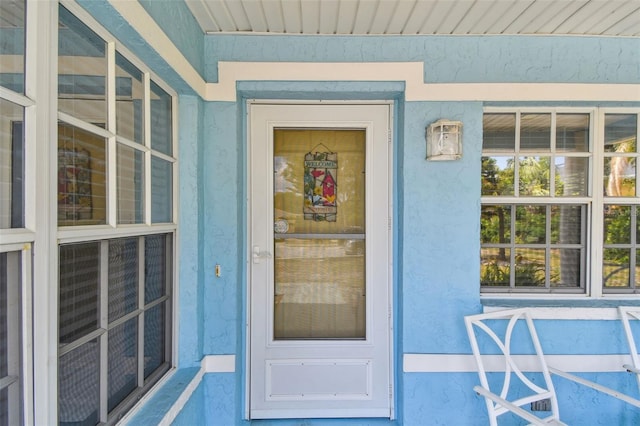 property entrance with stucco siding