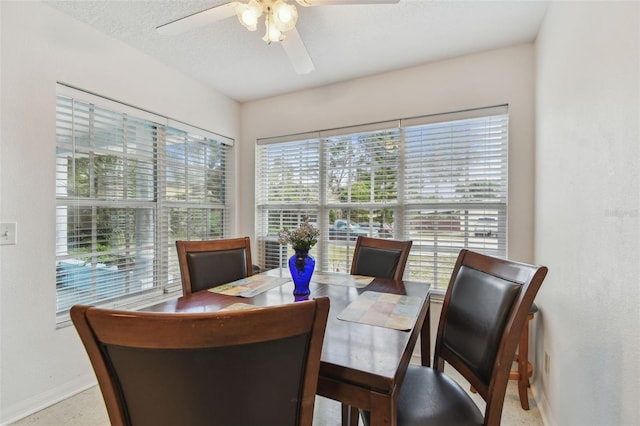 dining space featuring ceiling fan, baseboards, and a textured ceiling