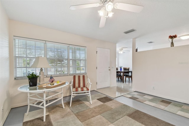 living area featuring ceiling fan, baseboards, and visible vents