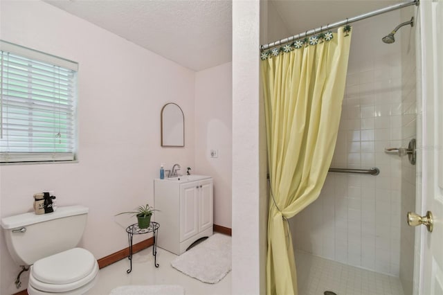 full bathroom featuring baseboards, toilet, a textured ceiling, a shower stall, and vanity