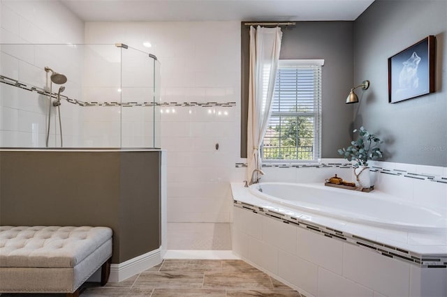 bathroom with walk in shower and a garden tub