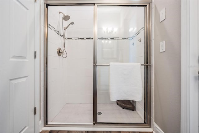 full bathroom with a shower stall and a textured wall