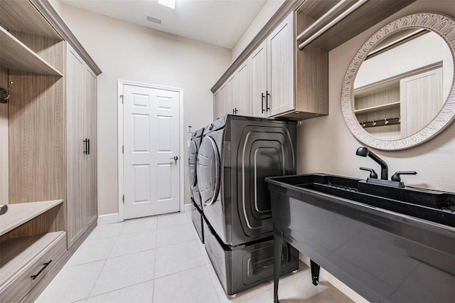 laundry room featuring visible vents, light tile patterned flooring, washing machine and clothes dryer, baseboards, and cabinet space