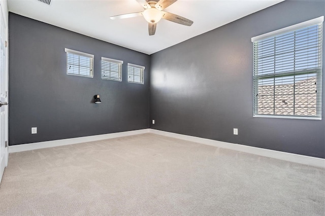 carpeted empty room featuring ceiling fan and baseboards