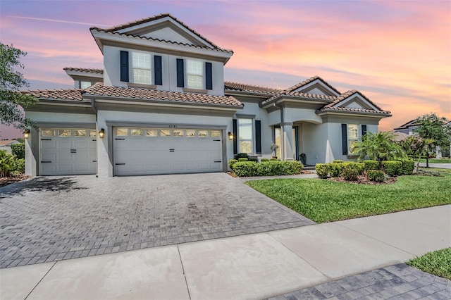 13121 Pasture View Loop, Riverview, FL 33579 - mediterranean / spanish house with decorative driveway, a tiled roof, stucco siding, a lawn, and an attached garage