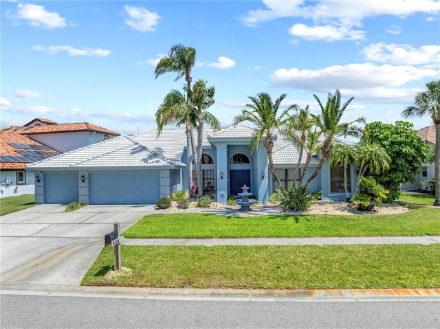 view of front of property with concrete driveway, stucco siding, an attached garage, a tiled roof, and a front lawn
