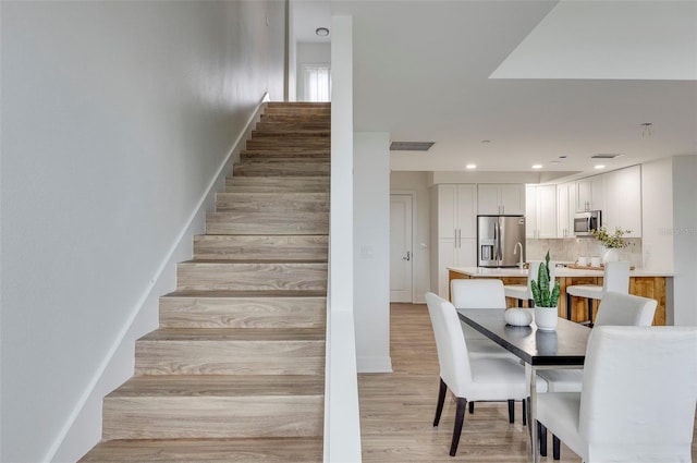 331 Cleveland St Unit 320, Clearwater, FL 33755 - stairway featuring baseboards, visible vents, wood finished floors, and recessed lighting