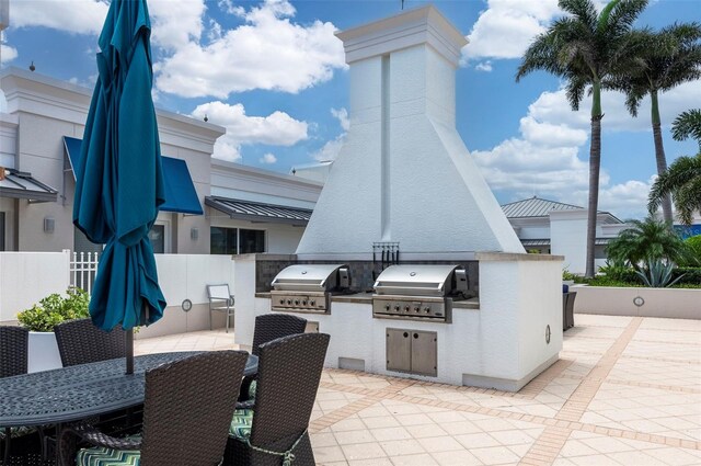 331 Cleveland St Unit 320, Clearwater, FL 33755 - view of patio / terrace featuring fence, outdoor dining space, grilling area, and an outdoor kitchen