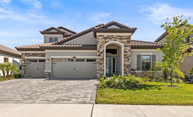 11014 Rustic Timber Loop, San Antonio, FL 33576 - mediterranean / spanish home featuring a tile roof, a garage, a front yard, stucco siding, and decorative driveway