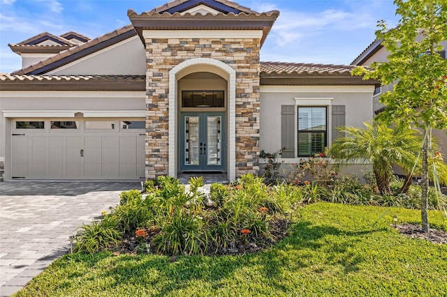 11014 Rustic Timber Loop, San Antonio, FL 33576 - view of front of property with french doors, a tile roof, an attached garage, and decorative driveway