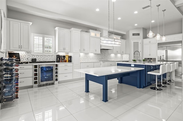 11014 Rustic Timber Loop, San Antonio, FL 33576 - kitchen featuring a kitchen breakfast bar, a large island with sink, wine cooler, visible vents, and built in refrigerator