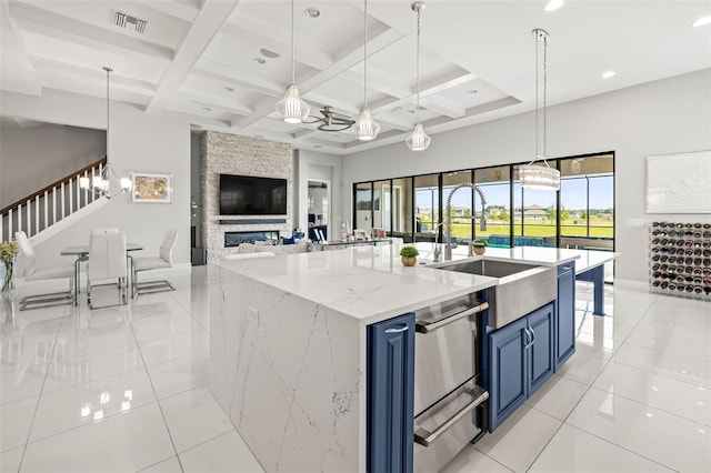 11014 Rustic Timber Loop, San Antonio, FL 33576 - kitchen with visible vents, light tile patterned floors, beamed ceiling, blue cabinetry, and open floor plan