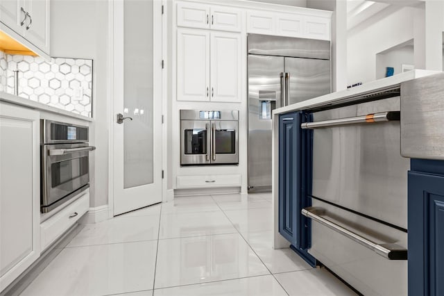 11014 Rustic Timber Loop, San Antonio, FL 33576 - kitchen featuring decorative backsplash, appliances with stainless steel finishes, blue cabinetry, and white cabinetry