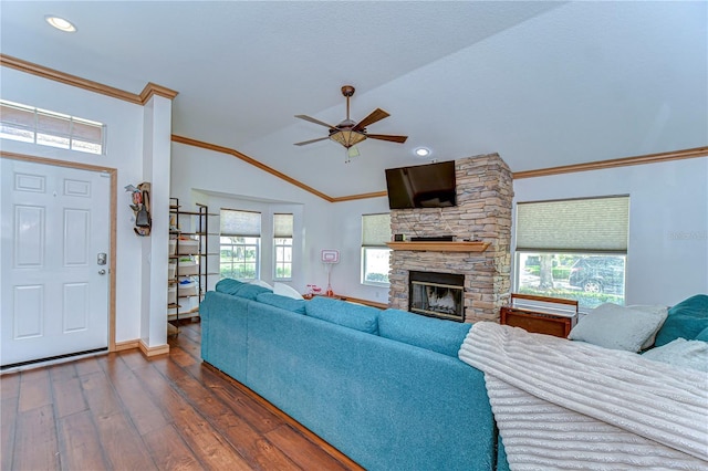 living area with plenty of natural light, dark wood-style flooring, ornamental molding, a fireplace, and vaulted ceiling