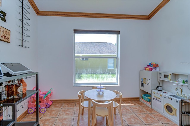rec room with a healthy amount of sunlight, light tile patterned floors, and ornamental molding