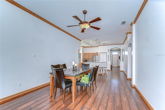 dining area featuring baseboards, visible vents, dark wood finished floors, arched walkways, and ceiling fan