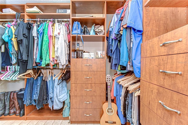 walk in closet with wood finished floors