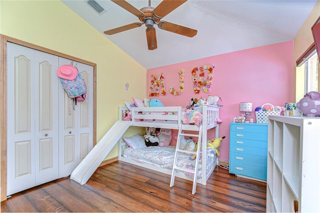 bedroom with visible vents, vaulted ceiling, wood finished floors, and a closet