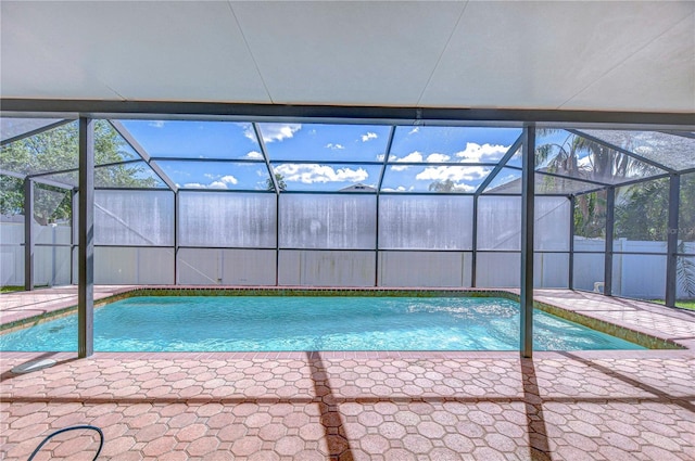 view of pool with a patio area, a fenced in pool, fence, and glass enclosure