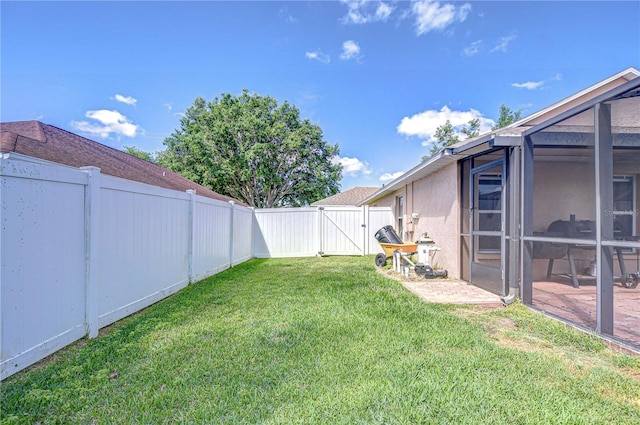 view of yard featuring a fenced backyard, a lanai, and a gate