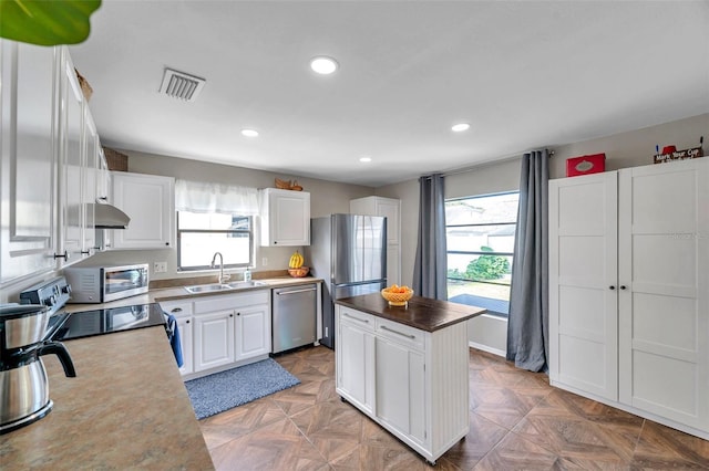 13308 Kearney Way, Tampa, FL 33626 - kitchen with a kitchen island, a wealth of natural light, visible vents, and stainless steel appliances