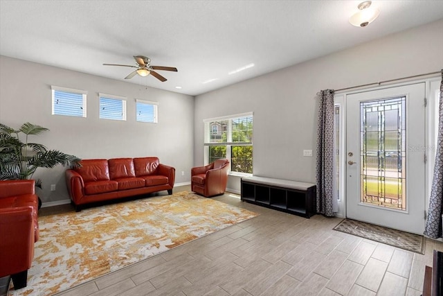 living room with ceiling fan, baseboards, and wood tiled floor