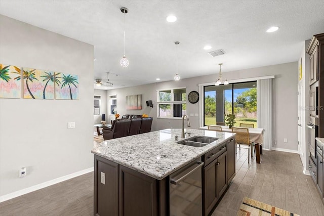 kitchen featuring baseboards, visible vents, stainless steel appliances, a sink, and wood finished floors