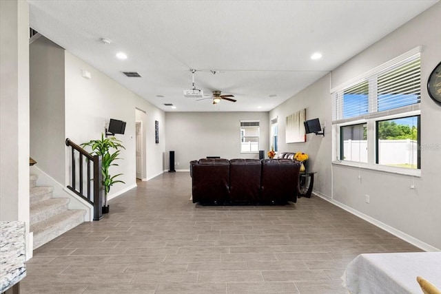 living room featuring baseboards, recessed lighting, stairway, a ceiling fan, and visible vents