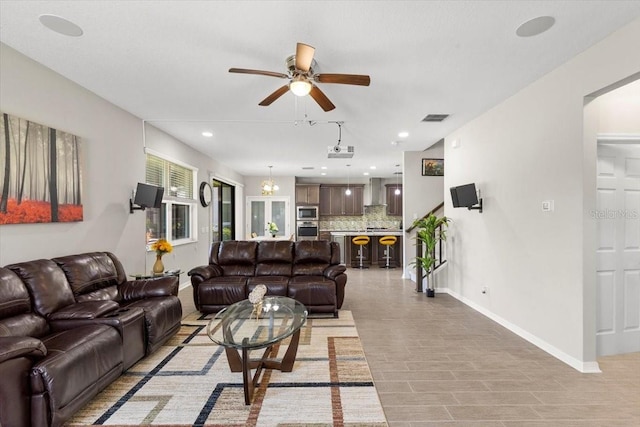living area with ceiling fan, baseboards, visible vents, and recessed lighting