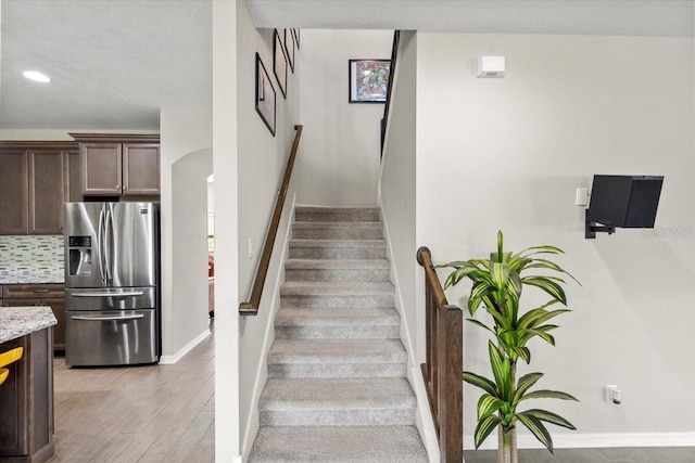 staircase featuring baseboards, recessed lighting, and wood finished floors