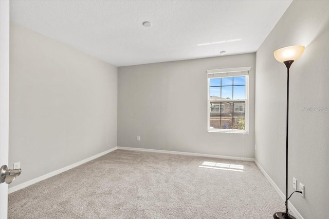 unfurnished room featuring carpet flooring and baseboards