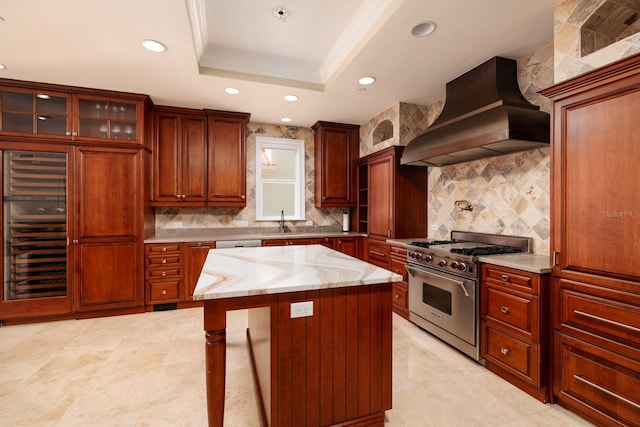 kitchen featuring a sink, ornamental molding, a tray ceiling, high end stainless steel range, and custom range hood