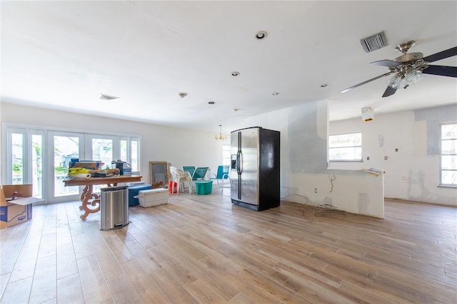 interior space with visible vents, light wood-style floors, french doors, and a ceiling fan