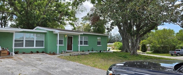 ranch-style house with a front yard and stucco siding